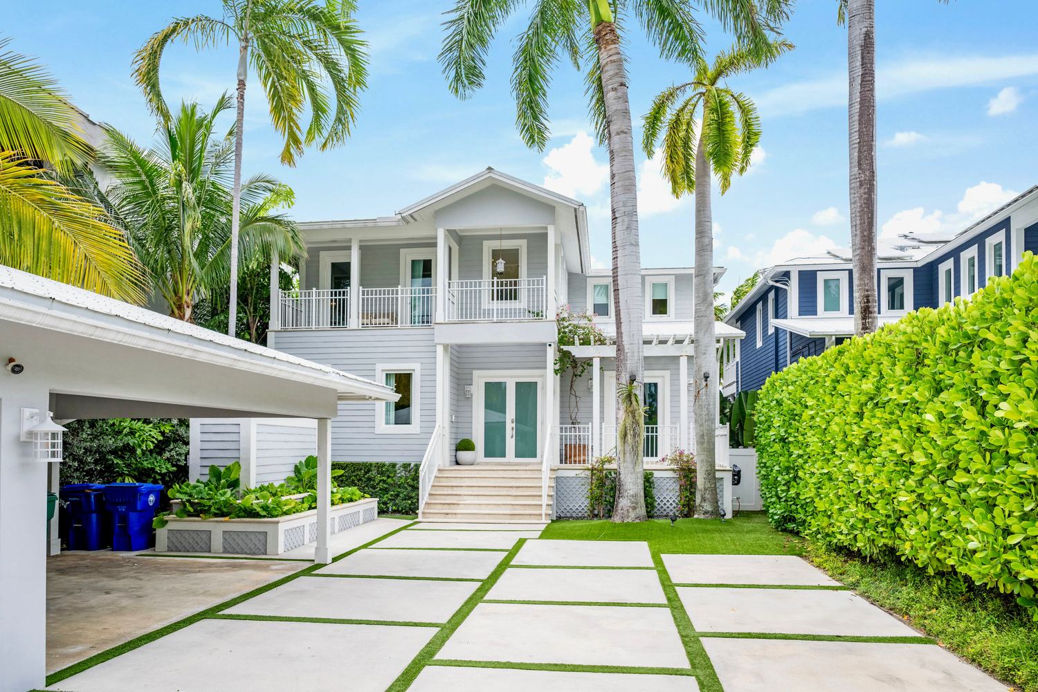 Two story coastal home under royal palms in Belle Meade, Miami