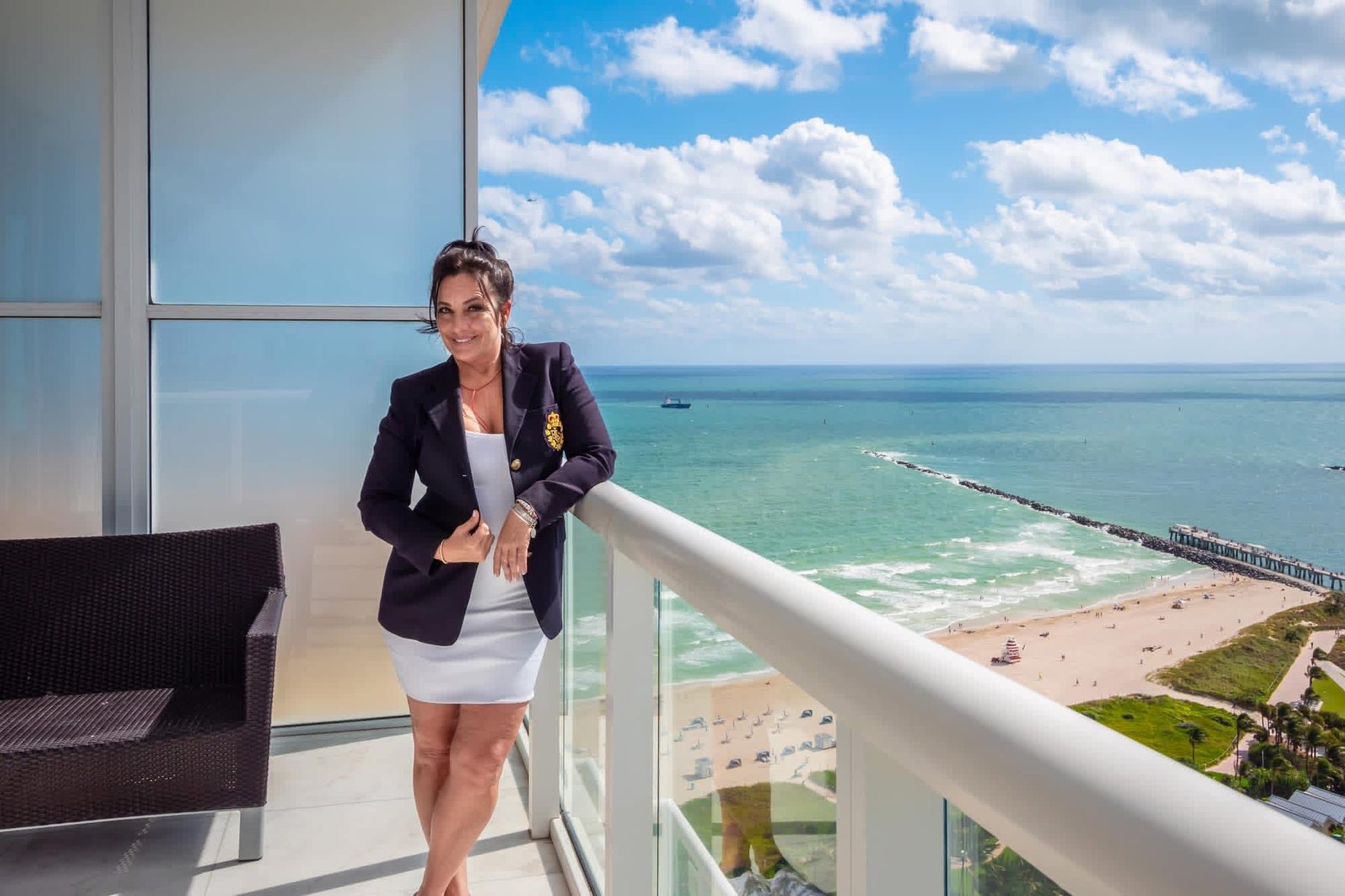 June Savage on a penthouse balcony overlooking South Beach and the Atlantic